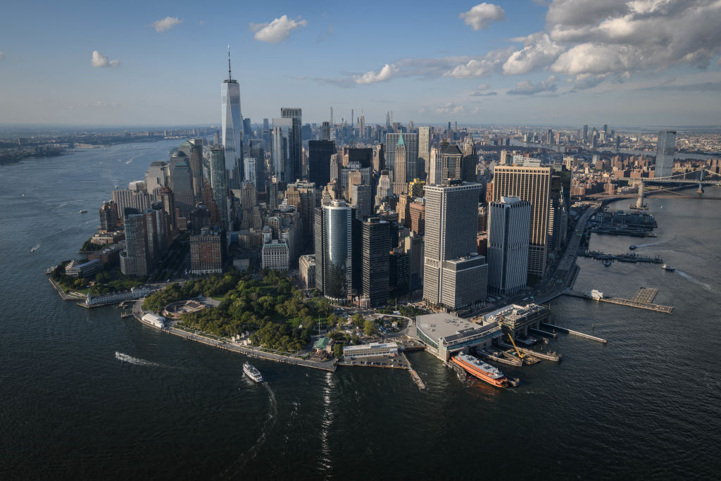 Fotografía aérea de la ciudad de Nueva York con sus rascacielos y el skyline, simbolizando la presión urbana sobre el terreno. Estilo cinematográfico, alta definición.