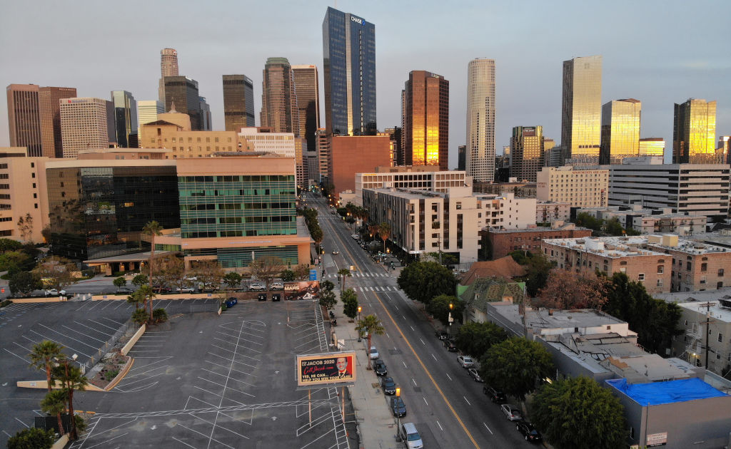 Vista aérea de Los Ángeles, California, con la icónica red de autopistas y edificios, superpuesta con un efecto visual que sugiere la subsidencia del terreno. Alta definición.