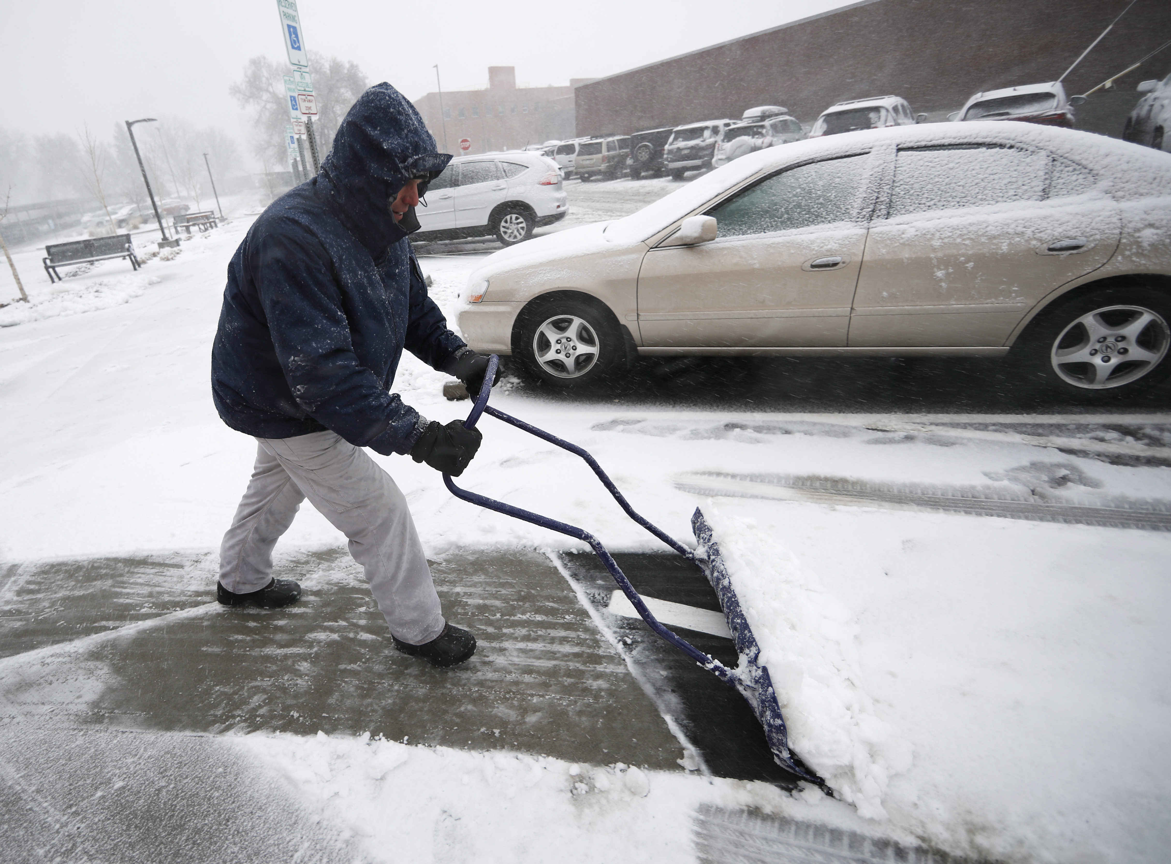 Neil Alderson, ex director ejecutivo de Schlessman YMCA, en Denver, remueve la gruesa capa de nieve que dejó el 'ciclón bomba' este miércoles en la ciudad.