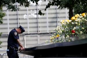 A NYPD officer pauses at the edge of the south reflecting pool at the National 9/11 Memorial and Museum during ceremonies marking the 16th anniversary of the attacks in New York
