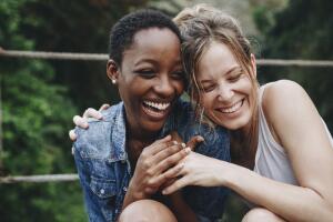 Duas mulheres sorrindo abraçadas