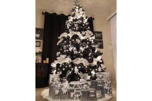 Árbol de Navidad negro con adornos blancos y muchas luces