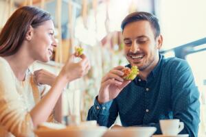 Beautiful young couple sitting in a cafe, having breakfast