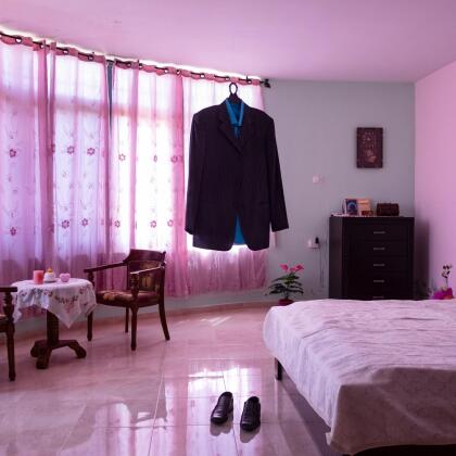 Fotografías ganadoras del World Press Photo 2021 | Al Dia Media Kobar (Palestine), 17/08/2015. The dress and shoes of the prisoner Nael Al Barghouti in his bedroom. His wife Iman keeps all her husband's clothes, shoes and items in their home. Nael was arrested on April 4, 1978 after carrying out a commando operation in which one Israeli was killed. Released during Shalit’s agreement between Hamas and Israel in 2011, he has been arrested again and sentenced to life imprisonment. He has spent 41 years in prison and he is longest-serving Palestinian inmate in Israeli jails. Items left behind by inmates allows us to perceive the absence of men and to understand the emptiness they left in the life of their family members. At the same time, the prisoners' wives also keep these objects in the hope of a return home of their loved ones. This photo was taken during a meeting with Iman in her home. Thanks to the confidence gained with her during the years of working in Palestine, I had the opportunity to photograph some of the private objects left by her husband at home.