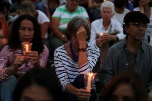 People attend a candlelight vigil held for victims of recent violence in Caracas