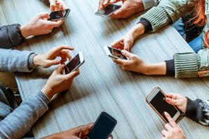 Personas con celulares en la mano