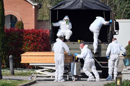 <b>Un país rebasado por la tragedia.</b> Decenas de ataúdes con víctimas del coronavirus fueron descargados en el cementerio de Ferrara, en el norte de Italia, el 21 de marzo. Fueron enviados desde Bérgamo, epicentro del brote de coronavirus en la región. La morgue de esa ciudad alcanzó su capacidad máxima y los cuerpos de algunos fallecidos por el covid-19 fueron trasladadas a otras ciudades. En Italia hay casi 70,000 infectados y han muerto más de 6,000 personas.
