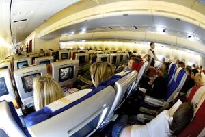 passengers sitting in the economy-class cabin seats watching the inflight entertainment on a Virgin Atlantic Airways Boeing 747-400 flying enroute LHR-JFK as flight-number VS003