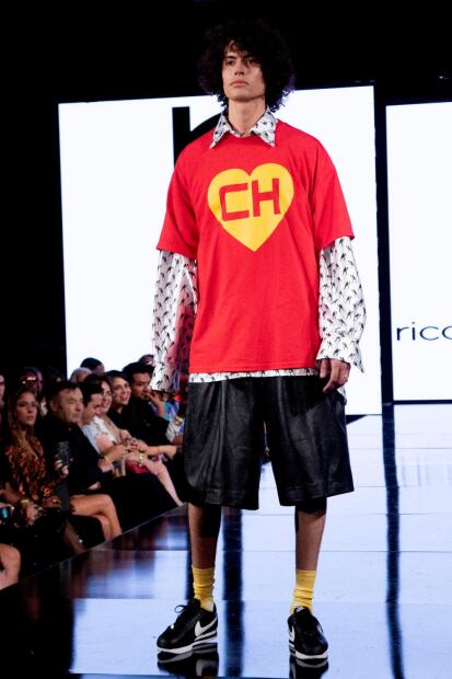No falta la camiseta con 
<b>el corazÃ³n amarillo y la CH</b>, que puede complementarse con otra camisa, de manga larga, incluida en ’Astucia’.»></div>
<div></div>
<div>En la colección se pueden ver los corazones rojos, los colores del traje del «Chapulín», las letras «CH», y hasta las «antenitas de vinil», representadas en los peinados de cada modelo. Algunos varones portaron playeras con la palabra «Chanfle», característica de «Chespirito».</div>
<div></div>
<div><img decoding=
