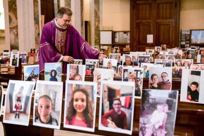 <b>Una misa sin fieles.</b> Giuseppe Corbari, párroco de una Iglesia en Giussano, en el norte de Italia, coloca en los asientos las fotografías de los que no pueden asistir a la misa por estar en cuarentena. 22 de marzo.