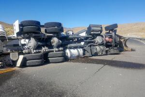 Crashed cement or concrete truck on its side on a roadway.