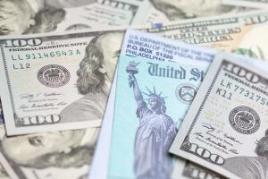 United States IRS Check and Envelope Resting on Money.