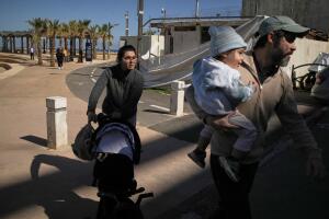 Una pareja con sus dos hijos corre a un refugio después de que suena una sirena de advertencia tras los ataques israelíes en Irán, en Haifa.
