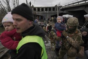 Centenares de personas abandonan la ciudad de Irpin bajo las ruinas de un puente destruido por las tropas rusas.