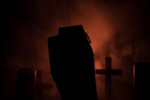Scary view of zombies at cemetery dead tree, moon, church and spooky cloudy sky with fog, Horror Halloween concept with glowing pumpkin. Selective focus