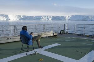 Ian in Antarctica Sitting on Ship with Headphones