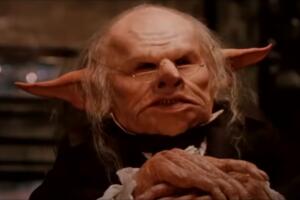 Warwick Davis en Harry Potter and the Sorcerer's Stone goblin banco.jpg