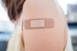 Adhesive bandage on a female arm after vaccination