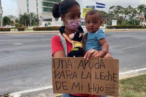 una madre con su hijo piden ayuda al lado de la carretera en Sam Pedro Sula.