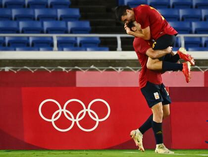 Spain's Mikel Oyarzabal celebrates with teammate Pedri Gonzalez (top) after scoring against Brazil during the Tokyo 2020 Olympic Games football competition men's gold medal match at Yokohama International Stadium in Yokohama, Japan, on August 7, 2021. (Photo by LOIC VENANCE / AFP) (Photo by LOIC VENANCE/AFP via Getty Images)