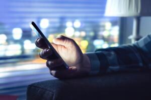 Phone with fraud text message, unknown scam call or night texting. Man using smartphone. Anonymous caller or sms scammer. Cheater with secret dating.