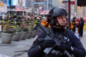 Police officers and fire crew stand outside the New York Port Authority Bus Terminal in New York City after reports of an explosion.