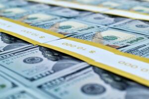 Many wads of one hundred dollar bills in a bank package.