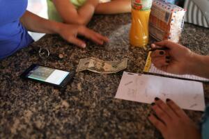 A woman pays with U.S. dollars in a bakery during an ongoing blackout in Caracas