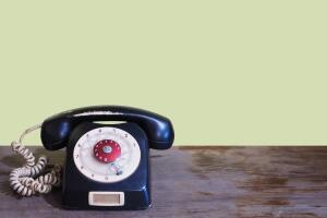 Black vintage telephone on wooden table