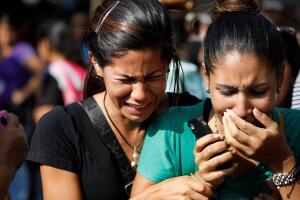 Relatives of inmates at the General Command of the Carabobo Police react as they wait outside the prison in Valencia