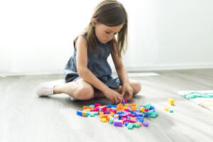 Girl (6-7) playing with plastic blocks