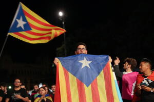 Un hombre sostiene una estelada, la bandera independentista catalana, durante el discurso de la noche en Barcelona donde se anunciaron los resultados del cuestionado referéndum y la intención de proseguir con el proceso de separación de España.