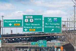 Road sign to interstate highway i-95, Port Newark, airport, Raymond boulevard for truck only with overpass exits