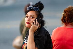 A woman is seen on her phone near the scene of a mass shooting during the Gilroy Garlic Festival in Gilroy, California