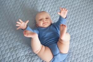 bebé niño vestido de azul levantando las piernitas