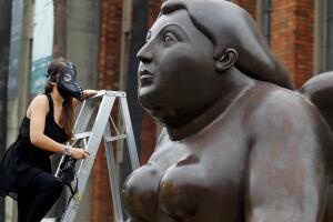 A group of environmentalists place gas masks on the faces of the sculptures of the artist Fernando Botero, protesting the high levels of air pollution in Medellin