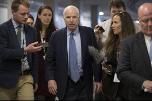 El senador John McCain rodeado de reporteros.