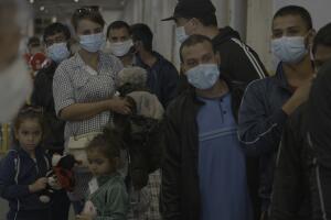 Groups of migrants gather, some very young and unmasked.jpg