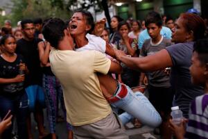 Relatives of inmates held at the General Command of the Carabobo Police react as they wait outside the prison in Valencia