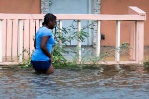 A woman walks in a flooded street after the effects of Hurricane Dorian arrived in Nassau