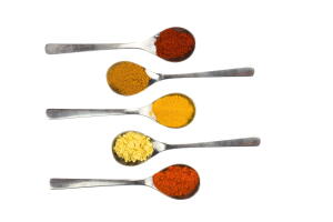 Various seasoning spices on metal spoons