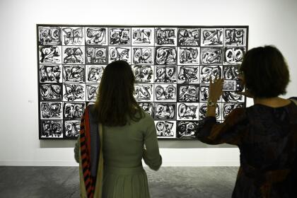 Attendees admire art at the VIP preview day for Art Basel on Wednesday, Dec. 4, 2024, at Miami Beach Convention Center in Miami Beach. (Photo by Scott Roth/Invision/AP)