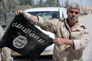 Un soldado sirio muestra una bandera capturada a milicianos de ISIS o Estado Islámico en abril de 2016.