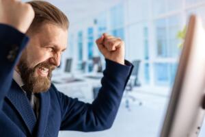 hombre celebrando frente a su computadora.jpg