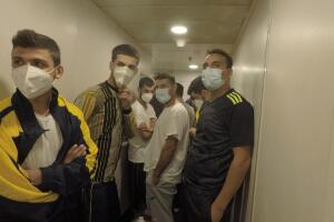 Masked migrants hang in the hallways.jpg
