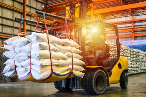 Forklift handling sugar bags for stuffing into container for export.