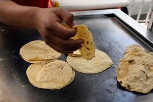 Taquero calentando tortillas.