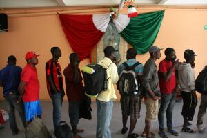 Una veintena de migrantes haitianos hace fila para utilizar las duchas en un refugio para migrantes de Tijuana