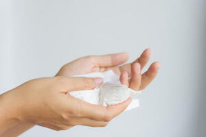 Woman cleaning her hands by using white tissue paper.  isolated 