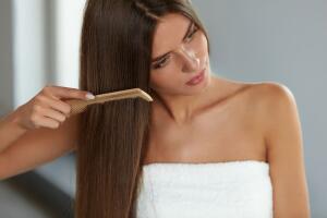 Brushing Hair. Woman Hairbrushing Beautiful Long Hair With Comb